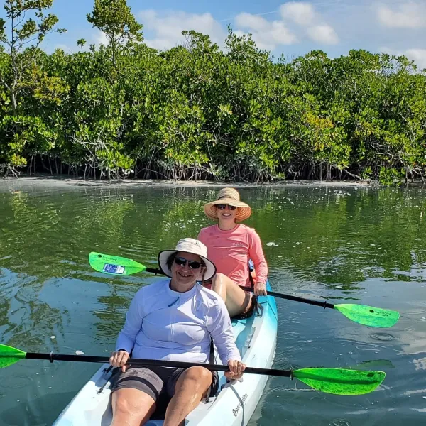 two people rowing a kayak in a body of water