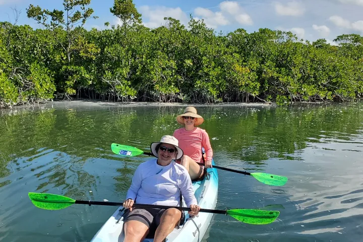 two people rowing a kayak in a body of water
